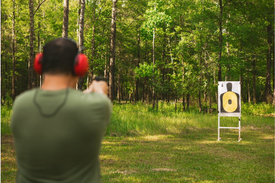 Man doing target practice to see how far a bullet can travel.