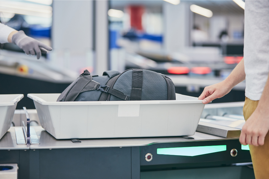 A person goes through the security screening with their bag of approved EDC.